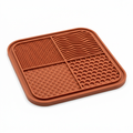 Terracotta pet lick mat with four textured sections on a white background